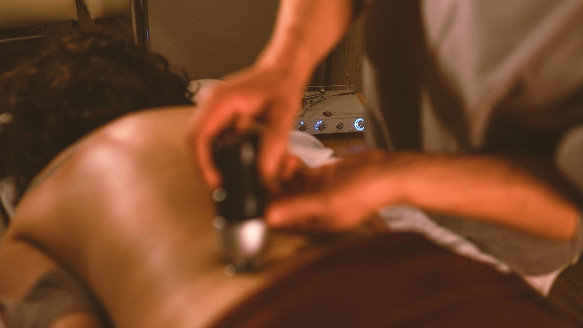 Eine Frau erhält eine professionelle Schallwellentherapie am Rücken, gezielt zur Verbesserung ihres Fasziengewebes und zur Lösung muskulärer Verspannungen.